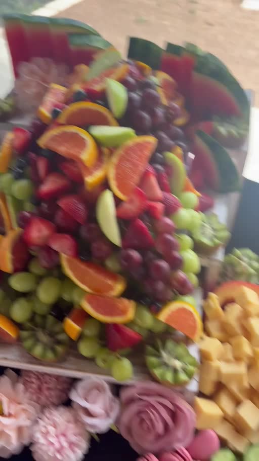 A colorful grazing table created by Rosabelle with cheeses, meats, fruits, vegetables, crackers and dips
